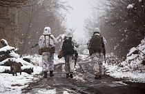 Soldados ucranianos caminham na linha de separação dos rebeldes pró-russos perto de Katerinivka, região de Donetsk, Ucrânia, terça-feira, 7 de dezembro de 2021.