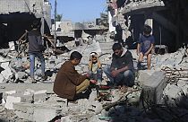Los palestinos cocinan pan junto a sus casas destruidas en Kuza'a, Franja de Gaza, durante el alto el fuego temporal entre Hamás e Israel el miércoles 29 de noviembre de 2023.