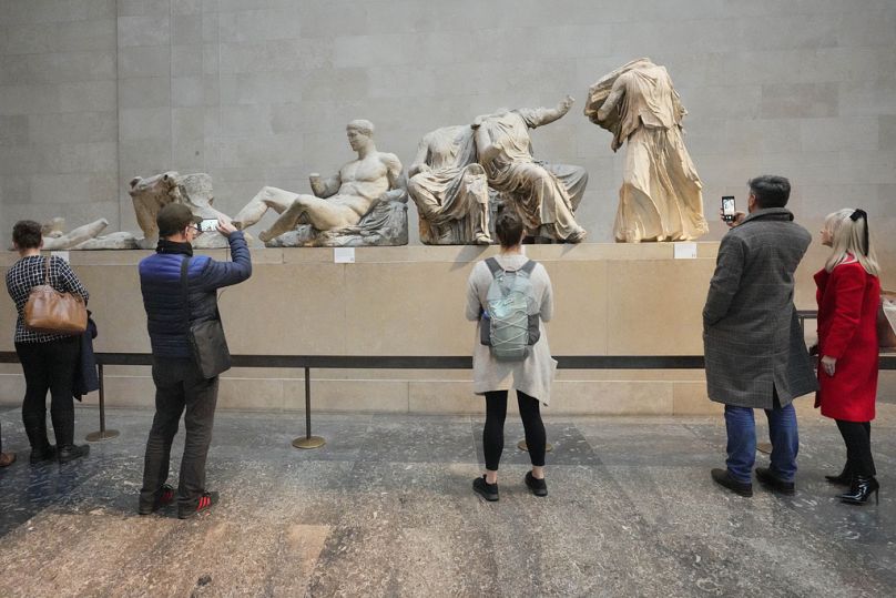 Visitors look at ancient sculptures that are part of the Parthenon Marbles at the British Museum in London, Tuesday, Nov. 28, 2023.