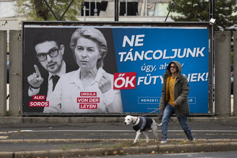 A government billboard reading "Let's not dance to their tune" is seen with portraits of Alex Soros and Ursula von der Leyen in downtown Budapest, November 2023