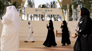 أناس يمشون في شارع بالقرب من مقر إقامة مؤتمر المناخ كوب 28 في دبي
