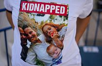 In Israele una manifestante per la libertà degli ostaggi indossa una maglietta che ritrae la famiglia Bibas