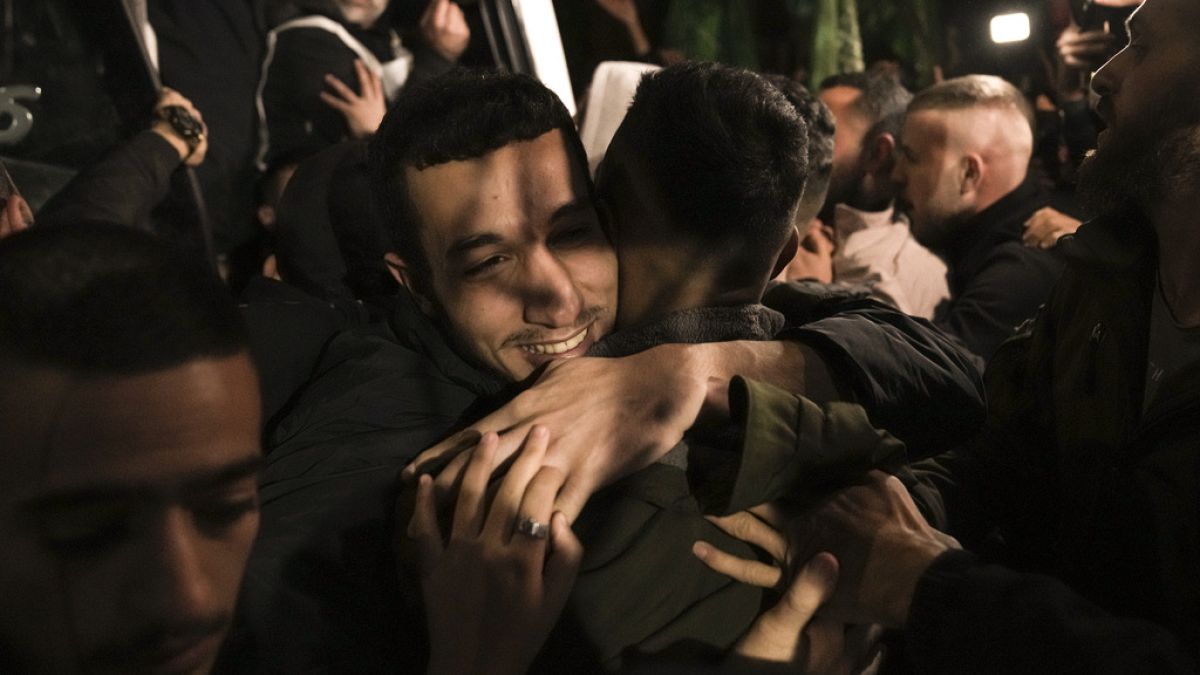 A man smiles as he is welcomed after being released from prison by Israel, in the West Bank town of Ramallah, early Thursday, Nov. 30, 2023. 