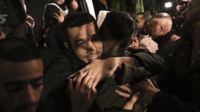 A man smiles as he is welcomed after being released from prison by Israel, in the West Bank town of Ramallah, early Thursday, Nov. 30, 2023. 