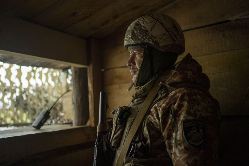 A soldier of the state border guard stands watch at a post where Ukrainian troops monitor Russian positions in the Sumy region, November 2023