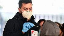 A medical staff member administers a test for whooping cough, as hundred of people queue in front of the national public health institute in Zagreb on November 29, 2023,