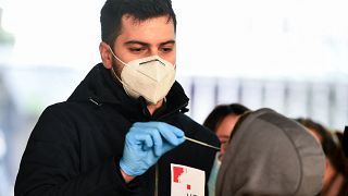 A medical staff member administers a test for whooping cough, as hundred of people queue in front of the national public health institute in Zagreb on November 29, 2023,