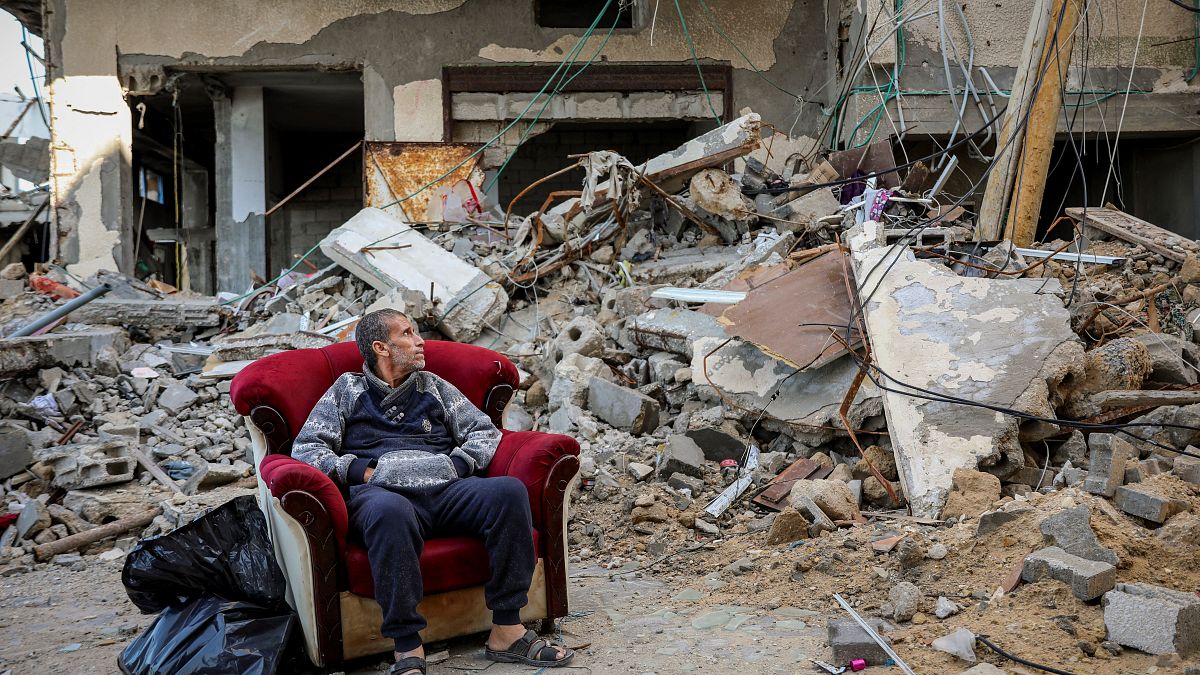 فلسطيني يجلس أمام أنقاض بيته المهدم