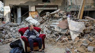 فلسطيني يجلس أمام أنقاض بيته المهدم