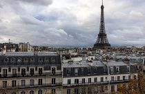 This photograph taken on November 21, 2023 shows the Eiffel Tower above the rooftops of Paris.