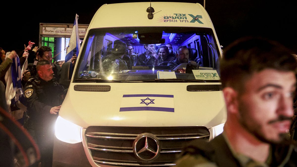 الرهائن الإسرائيليون المفرج عنهم حديثًا يجلسون بين الجنود عند وصولهم داخل مركبة في قاعدة أوفاكيم العسكرية في جنوب إسرائيل، في وقت مبكر من يوم 30 نوفمبر 2023.