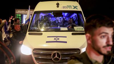 الرهائن الإسرائيليون المفرج عنهم حديثًا يجلسون بين الجنود عند وصولهم داخل مركبة في قاعدة أوفاكيم العسكرية في جنوب إسرائيل، في وقت مبكر من يوم 30 نوفمبر 2023.