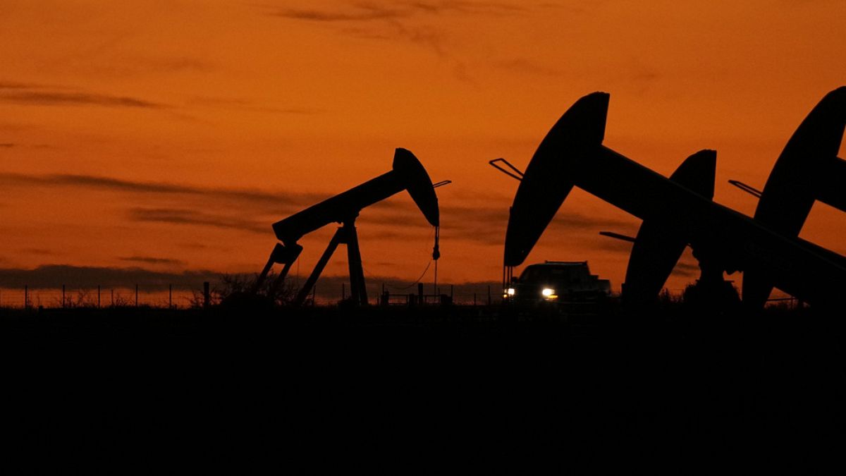 Un camión pasa entre extractores de petróleo al atardecer cerca de Karnes City, Texas, el miércoles 1 de noviembre de 2023.