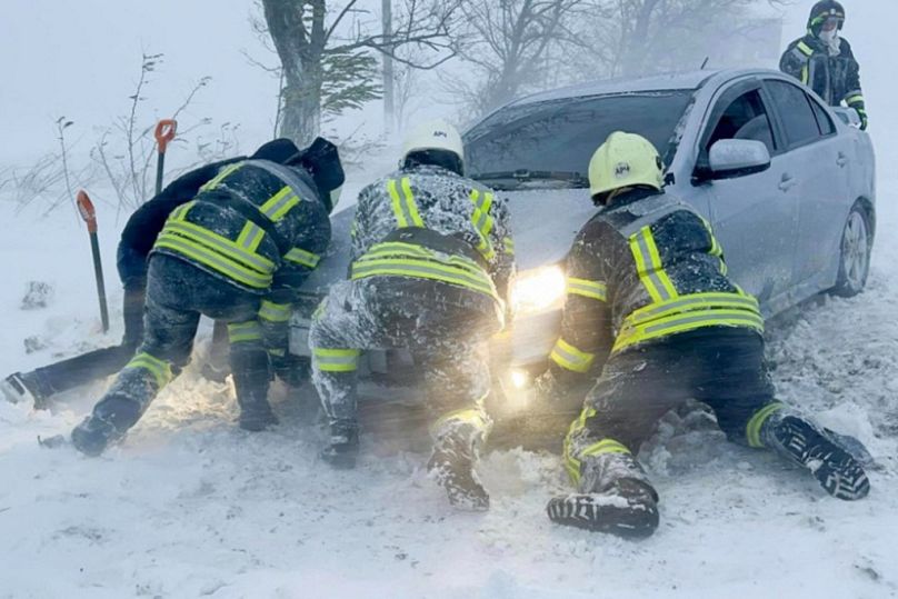 I servizi di emergenza ucraini cercano di far ripartire una macchina dopo la tempesta a Odessa