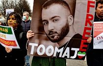 A woman holds a poster of rapper Toomaj Salehi, who was arrested over his support of the Mahsa Amini protests