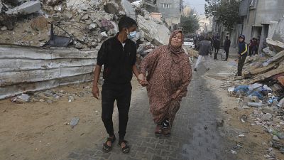 Egy légicsapásban megsérült nőt támogat egy férfi Gázában