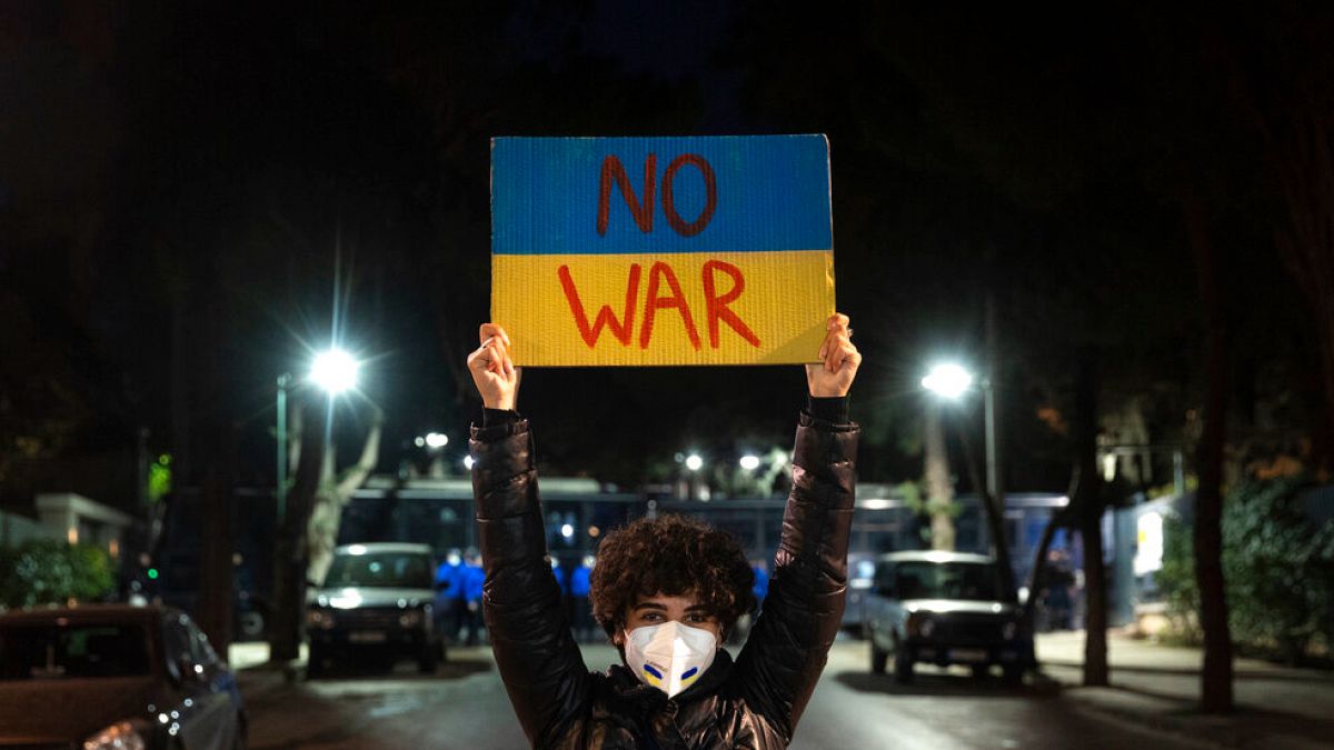 DATEI - Ein Demonstrant hält ein Plakat während eines Protestes gegen die russische Invasion in der Ukraine vor der russischen Botschaft in Athen am Freitag, 25\. Februar 2022, hoch.