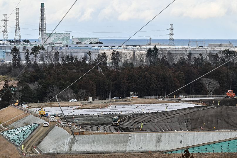 This photo taken on February 14, 2023 shows a site (bottom) where soil contaminated by the 2011 nuclear accident at the Fukushima Daiichi nuclear power plant (top) is placed a
