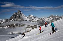 Skiers with the Matterhorn mountain as landscape near the 3,480-metre high Rifugio Guide del Cervino 