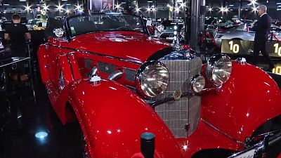 Imagen de un lujoso coche antiguo presentado en el marco de una exhibición del mundo del motor.