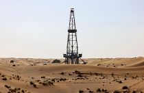 An oil drill pump amidst the sand dunes in the desert of the Gulf emirate of Dubai. 
