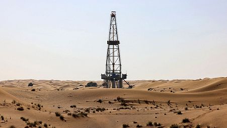 An oil drill pump amidst the sand dunes in the desert of the Gulf emirate of Dubai. 