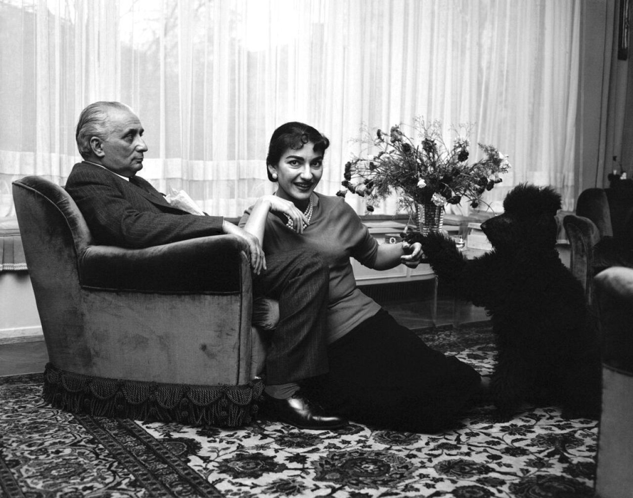 Renowned soprano Maria Meneghini-Callas plays with her poodle at home in Milan on Nov. 24, 1955, while her husband Giovanni Battista Meneghini, watches.