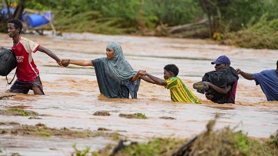  يعبر السكان طريقاً تضررت بسبب أمطار النينيو في كينيا