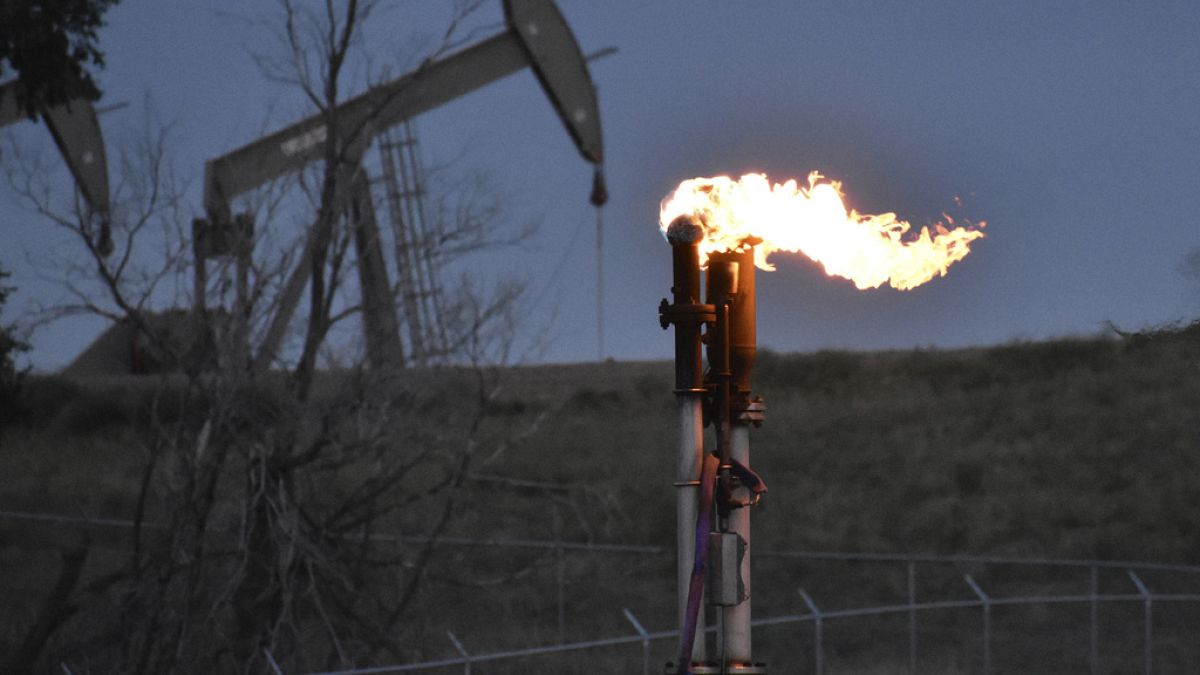 FILE - A flare to burn methane from oil production is seen on a well pad, Aug. 26, 2021, near Watford City, USA