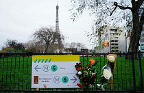Flowers are lain near where a tourist was stabbed to death near the Eiffel Tower in Paris