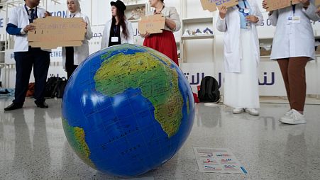 People participate in a demonstration to highlight the link between health and climate at COP28. 