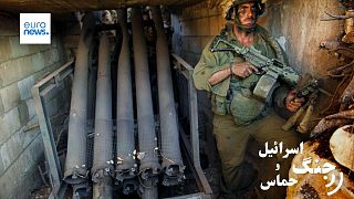 سرباز اسرائیلی در کنار راکت‌انداز متروکه حماس، عکس تزیینی و مربوط به سال ۲۰۰۶ میلادی است  