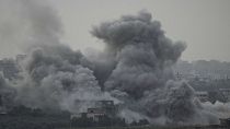 Nuvens de fumos e destroços de um bombardeamento israelita na Faixa de Gaza