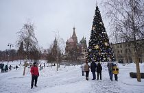 People walk past a Christmas Tree at Zaryadye Park near the Kremlin and Red Square after snow fall in Moscow, Russia, Tuesday, Nov. 28, 2023.