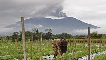 Γυναίκα δουλεύει στο χωράφι της στην Ινδονησία μετά την έκρηξη του ηφαιστείου Μαράπι