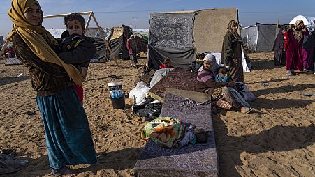 Palestinians displaced by the Israeli bombardment of the Gaza Strip gather at a tent camp, in Rafah, southern Gaza strip, Monday, Dec. 4, 2023. 