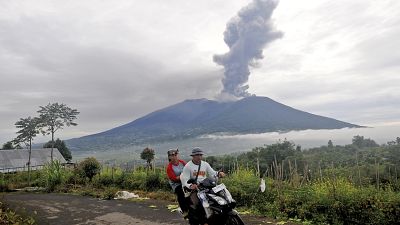 Automobilisti passano davanti al Monte Marapi che vomita materiale vulcanico durante la sua eruzione ad Agam, Sumatra occidentale, Indonesia, lunedì 4 dicembre 2023