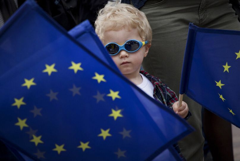 young boys waves an EU flag during a festival outside the European Parliament in Brussels, May 2019