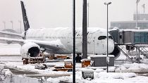 A Lufthansa aircraft is parked at the snow-covered Munich airport, Germany, Saturday, Dec. 2, 2023.