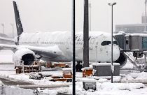 Un avion de la Lufthansa est stationné à l'aéroport enneigé de Munich, en Allemagne, le samedi 2 décembre 2023.