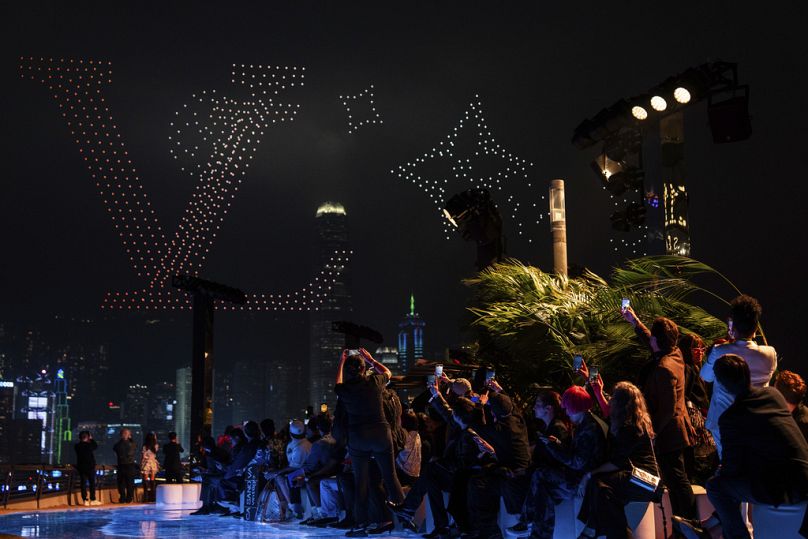 Guest take photographs of a drone show during the Louis Vuitton Men's Pre-Fall 2024 Fashion Show presented in Hong Kong, Thursday, Nov. 30, 2023.
