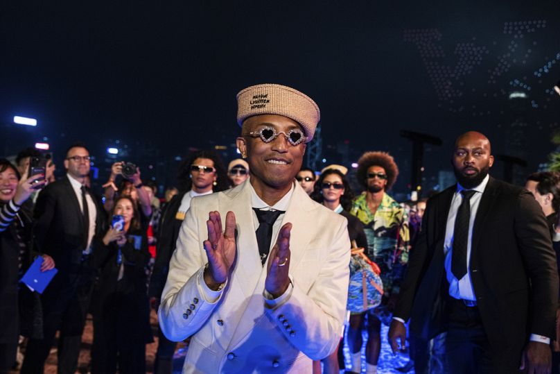 Designer Pharrell Williams applauds at the conclusion of the Louis Vuitton Men's Pre-Fall 2024 Fashion Show, presented in Hong Kong, Thursday, Nov. 30, 2023.