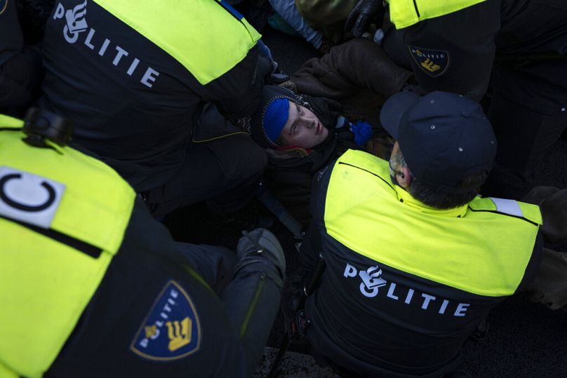 Police detained a protestor after Extinction Rebellion activists and sympathisers blocked a busy road in The Hague, January 2023