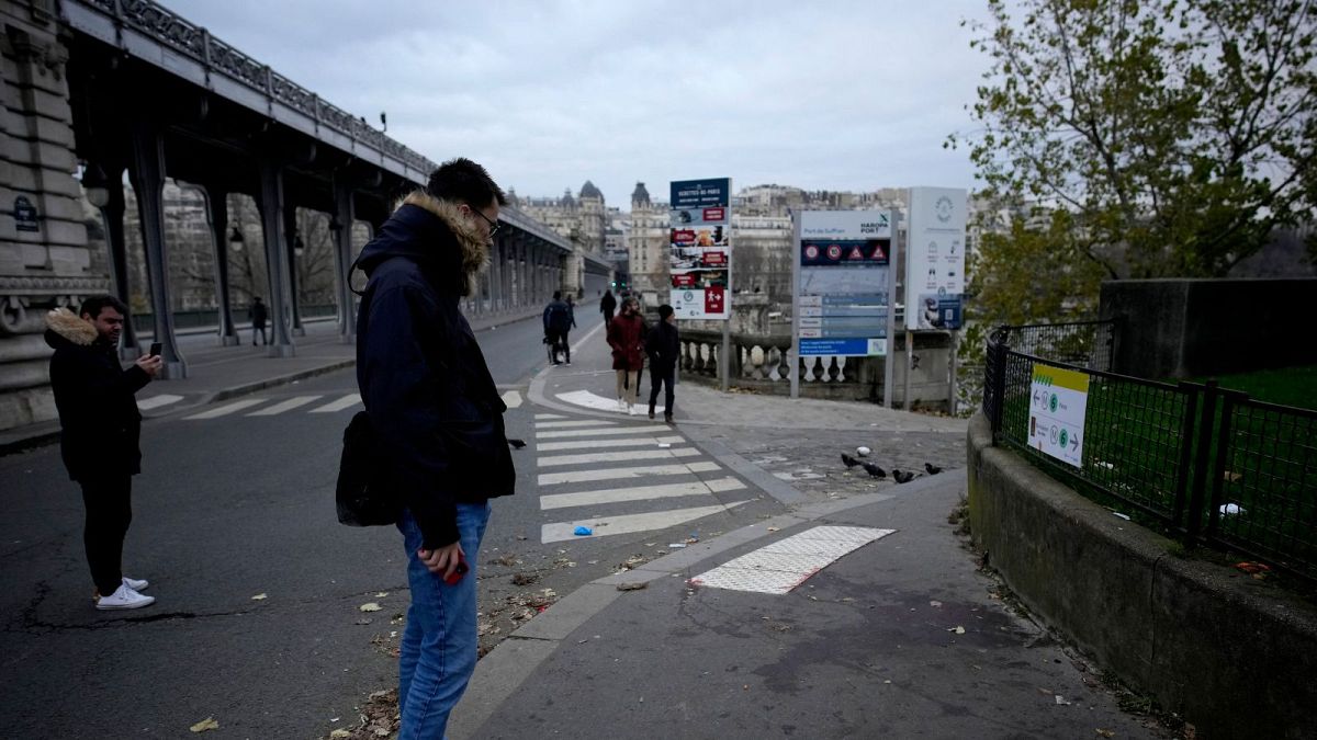 رهگذران در محل وقوع حمله با چاقو به یک گردشگر آلمانی در کنار پل «بئر حکیم» در شهر پاریس به تاریخ سوم دسامبر ۲۰۲۳