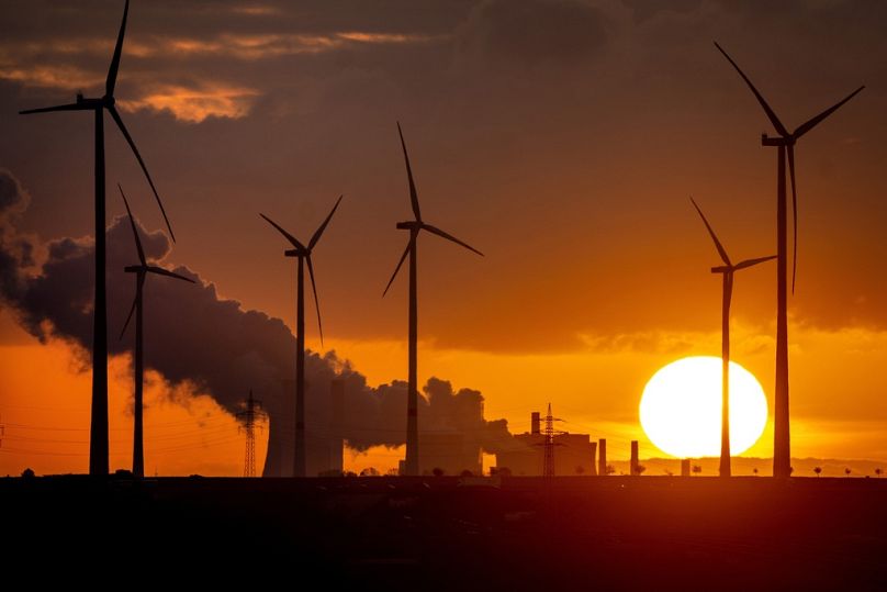 A coal-fired power plant operates near wind turbines Niederaussem, Germany.