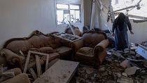 سيدة تتفقد أثر الدمار الذي خلقته غارة إسرائيلية على بيتها في خان يونس