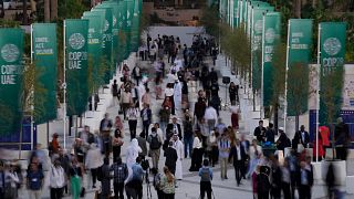 People walk through the COP28 UN Climate Summit.