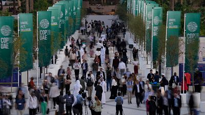 People walk through the COP28 UN Climate Summit.
