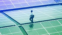 Mark Munyua, CP solar's technician, examines solar panels on the roof of a company in Nairobi, September 2023