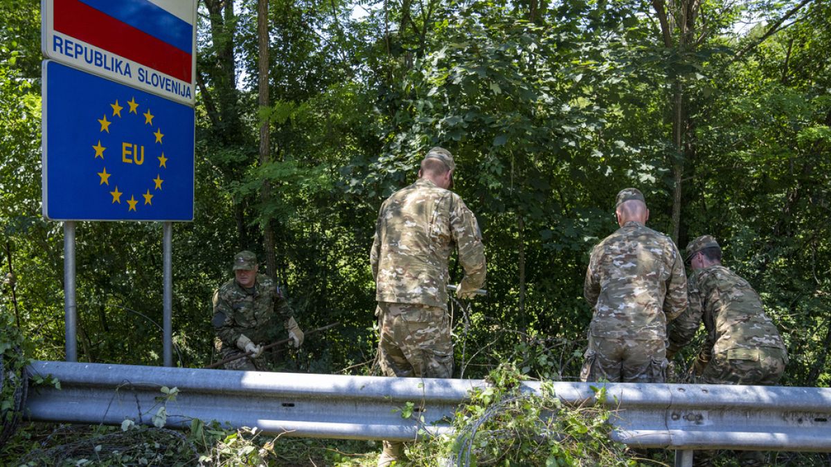 Soldati sloveni rimuovono la recinsione al confine con la Croazia. 